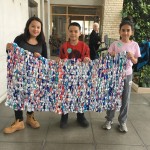 3 youth group members holding up milk mat